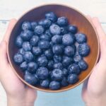 Mirtilli freschi in una ciotola, simbolo dei benefici per la salute quotidiana.