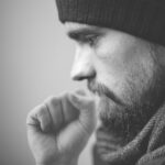 Immagine di un medico che esamina le corde vocali di un paziente con voce rauca.