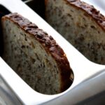 Fette biscottate integrali su un tavolo, accompagnate da marmellata e frutta fresca per una colazione sana.