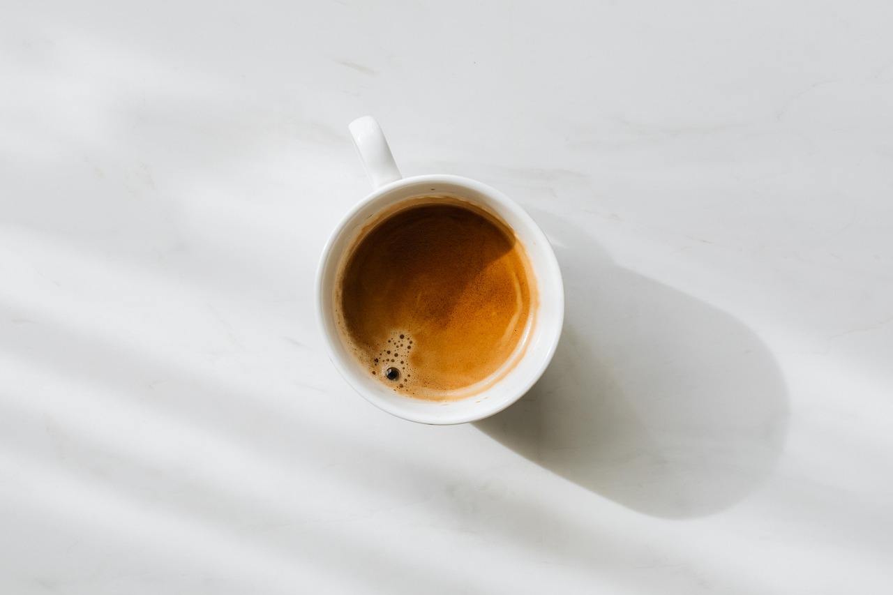 Caffè in tazza con espressione delusa, rappresenta marche di caffè da evitare per un buon espresso.