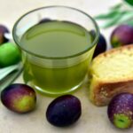 Olio extravergine d'oliva in un bicchiere, evidenziando colore e consistenza.