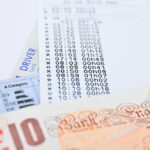 Uomo anziano sorride mentre guarda un documento sul bollo auto, rappresentando l'esenzione per chi ha una certa età.