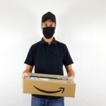 Immagine di un pacco Amazon con un'etichetta di rimborso e un laptop aperto con chat di assistenza clienti.
